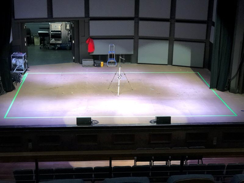 Shedd-temporary hearing loop on the stage of the Jaqua concert hall. Semi-aerial view showing a green rectangular tape on the gray stage floor