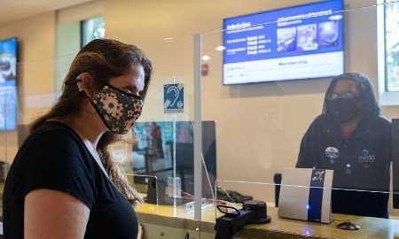 Shedd Aquarium ticket counter with two people and a counter hearing loop in between them